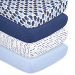 A stack of three blue and white patterned baby crib sheets.