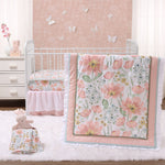 A nursery room with a white crib, a pink and white floral bedding set, and a small stuffed animal. The room has a pink and white color scheme, with a floral wallpaper and butterflies on the wall.